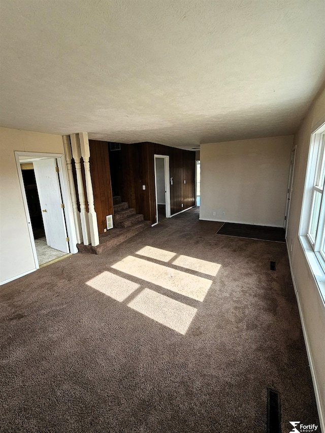 carpeted empty room with a textured ceiling