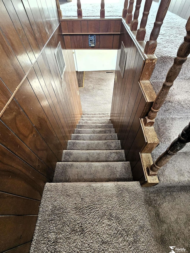 staircase featuring wooden walls