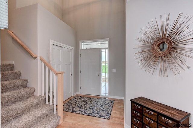 foyer with a high ceiling and light hardwood / wood-style flooring