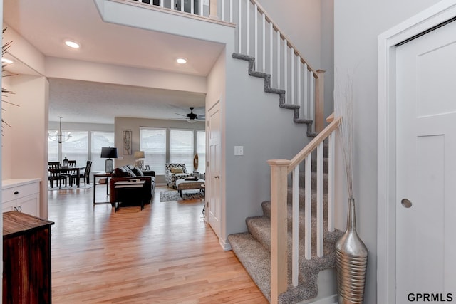 stairway featuring hardwood / wood-style flooring and ceiling fan