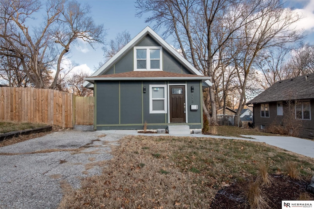 bungalow-style home with a front yard