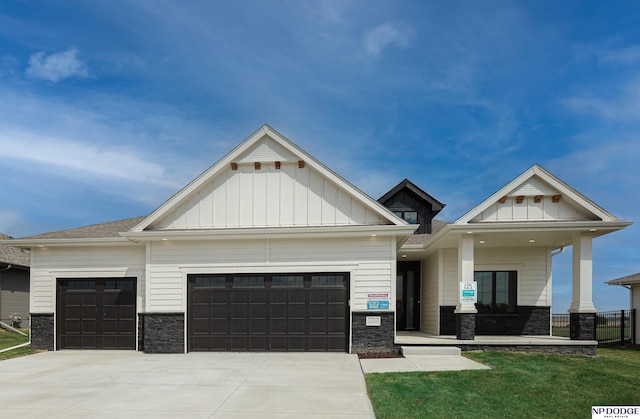 view of front of home with a porch, a garage, and a front yard