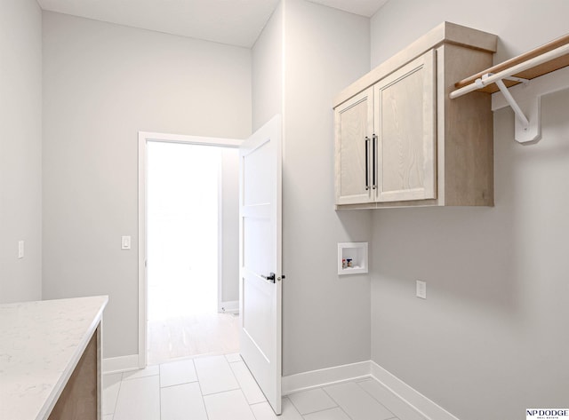 laundry area with cabinets, washer hookup, and light tile patterned floors