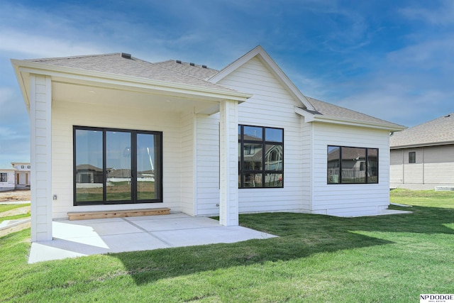 rear view of property with a lawn and a patio area