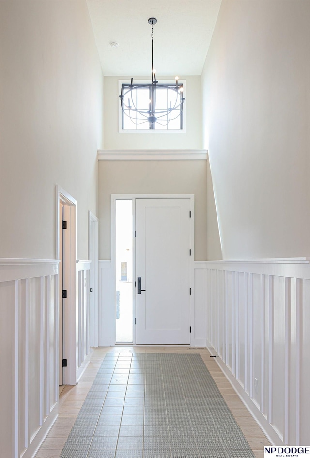 foyer entrance featuring plenty of natural light, a high ceiling, and an inviting chandelier