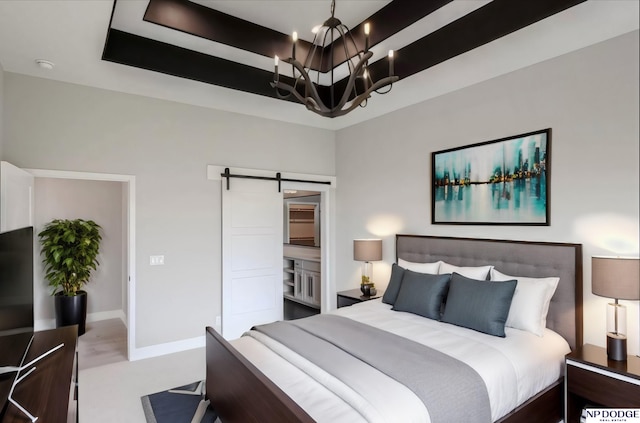 bedroom featuring a barn door, ensuite bathroom, and a notable chandelier