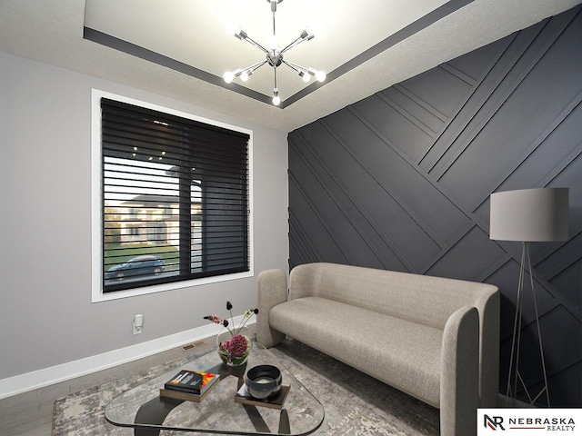 living area featuring baseboards, an accent wall, an inviting chandelier, a textured ceiling, and wood walls