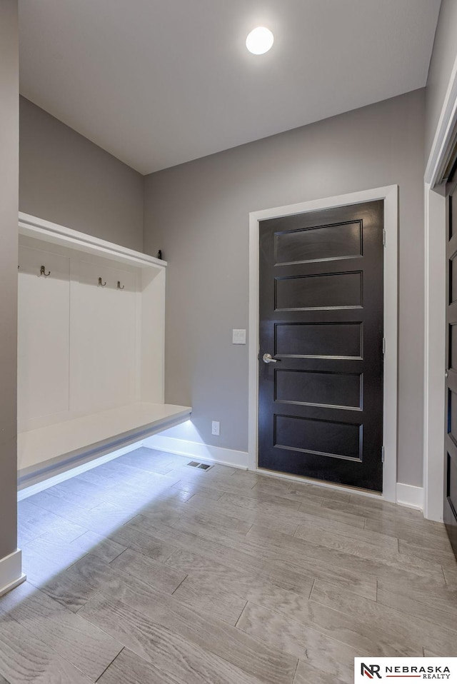 entrance foyer with wood finish floors, visible vents, and baseboards