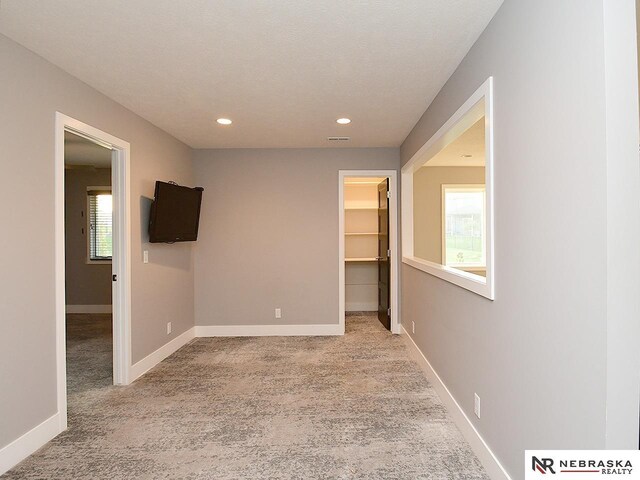 carpeted empty room featuring baseboards and recessed lighting