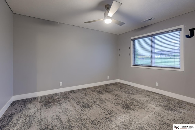 spare room with ceiling fan, visible vents, and baseboards