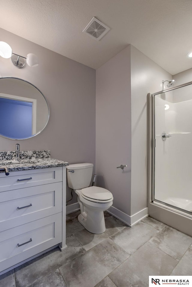 bathroom with vanity, toilet, and a shower with door