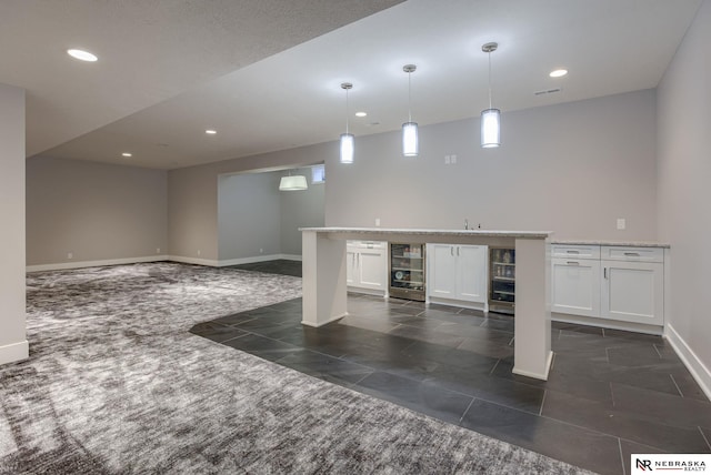 interior space featuring beverage cooler, visible vents, baseboards, indoor wet bar, and recessed lighting