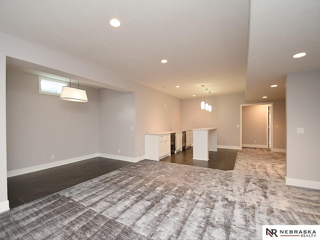 interior space with baseboards, dark colored carpet, and recessed lighting