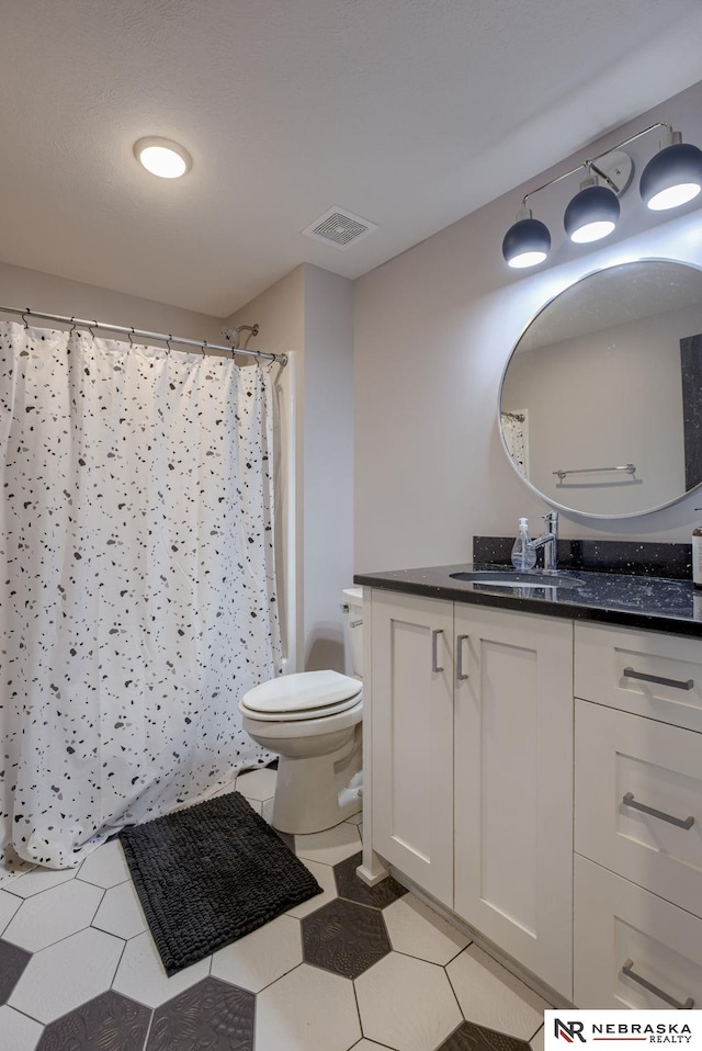 full bathroom featuring a shower with curtain, visible vents, vanity, and toilet