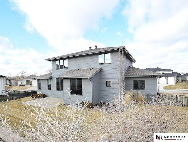 back of house featuring central AC unit, a patio area, a shingled roof, and fence