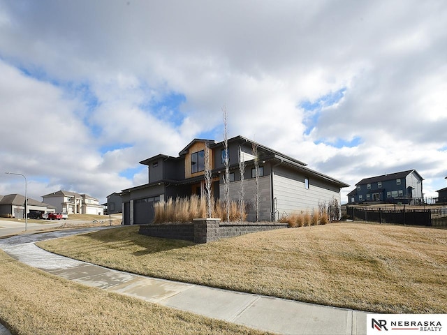 view of side of home featuring an attached garage and a lawn