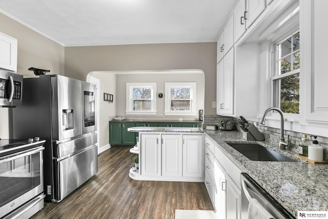 kitchen featuring light stone countertops, dark hardwood / wood-style floors, white cabinets, appliances with stainless steel finishes, and sink