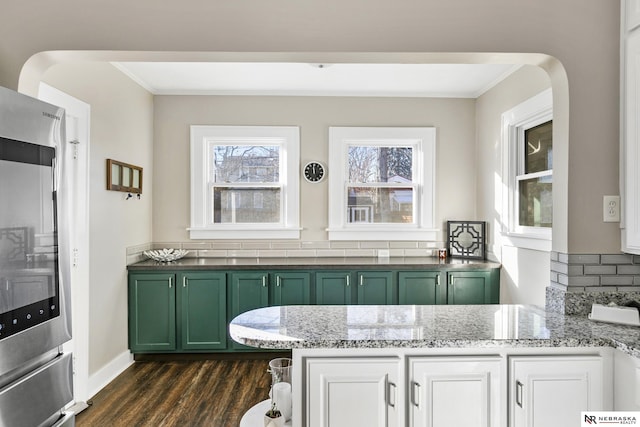 bar with green cabinets, white cabinetry, light stone countertops, stainless steel fridge, and dark hardwood / wood-style flooring