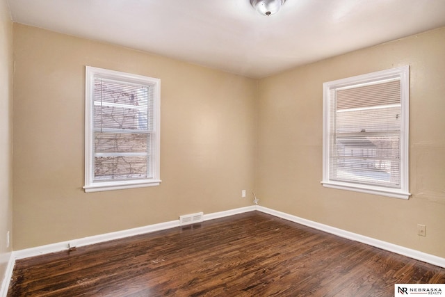 spare room with dark hardwood / wood-style flooring