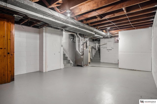 basement featuring electric panel and heating unit