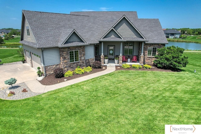 craftsman inspired home with covered porch, a water view, a garage, and a front yard