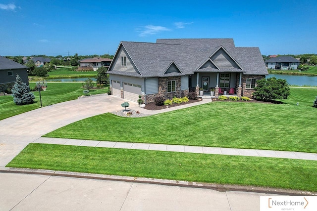 view of front of property featuring a garage, a water view, and a front yard