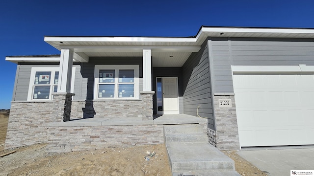 property entrance with a garage and covered porch