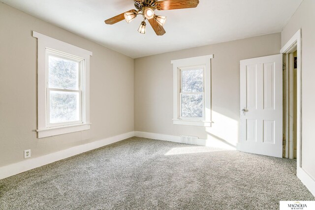 carpeted empty room featuring ceiling fan