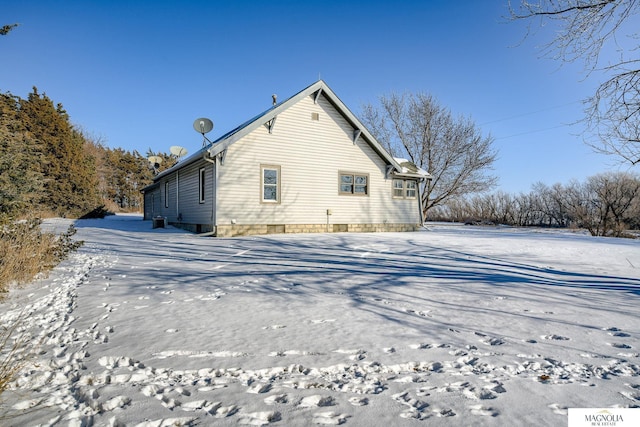 view of snow covered rear of property