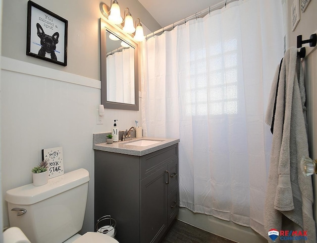 bathroom featuring a shower with curtain, vanity, and toilet