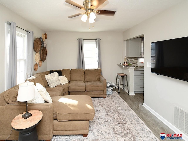 living room featuring hardwood / wood-style floors, ceiling fan, and a wealth of natural light