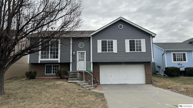 bi-level home featuring a garage and a front yard