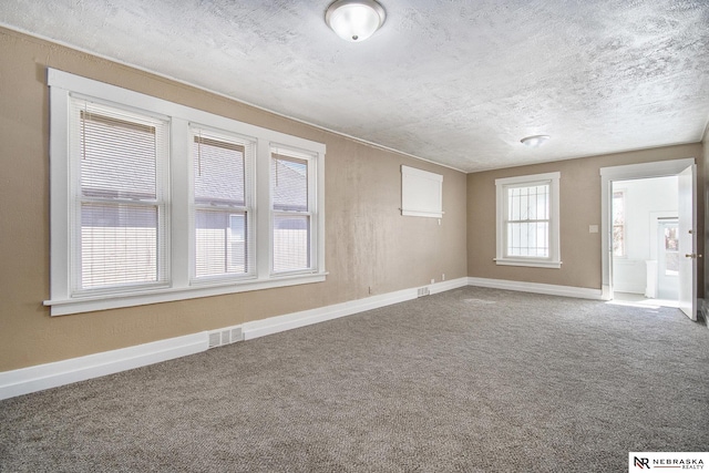 unfurnished room featuring carpet flooring and a textured ceiling