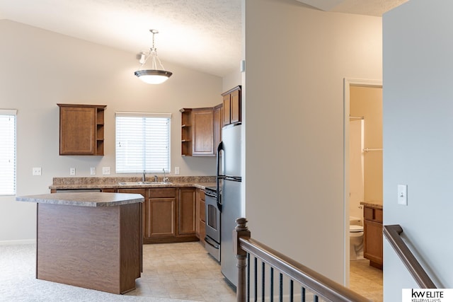 kitchen featuring a textured ceiling, stainless steel appliances, vaulted ceiling, sink, and hanging light fixtures