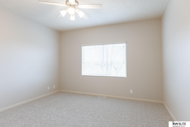 carpeted spare room featuring ceiling fan