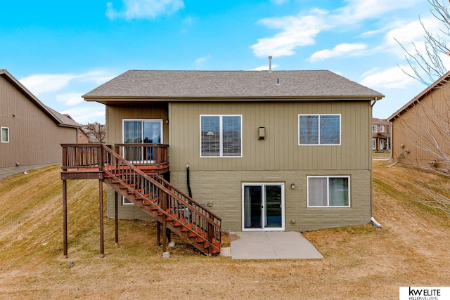 rear view of house featuring a wooden deck, a patio area, and a lawn