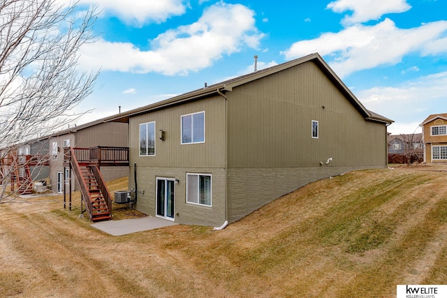 back of property featuring a wooden deck, a yard, and central AC unit