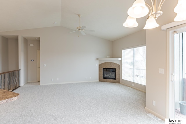 unfurnished living room featuring light carpet, ceiling fan with notable chandelier, vaulted ceiling, and a tile fireplace