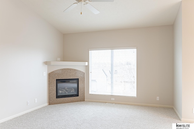 unfurnished living room featuring carpet flooring, a healthy amount of sunlight, and a tile fireplace