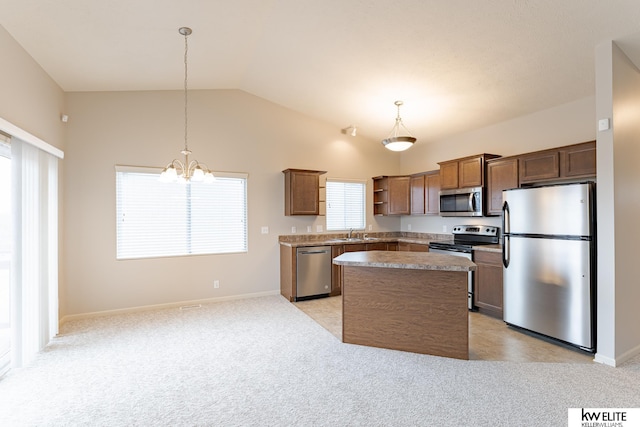 kitchen featuring sink, hanging light fixtures, an inviting chandelier, a kitchen island, and appliances with stainless steel finishes