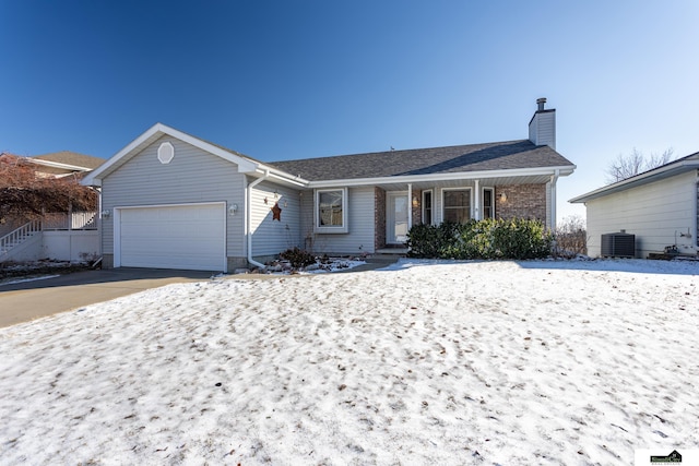 single story home with central AC unit and a garage