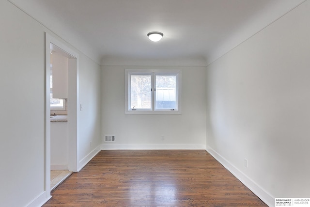 unfurnished room with dark wood-type flooring