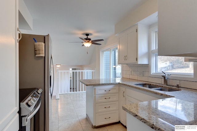 kitchen featuring sink, stainless steel electric range, white cabinetry, and backsplash