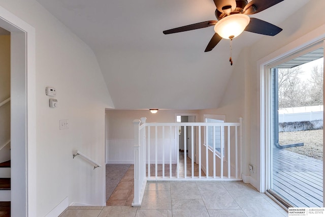 interior space featuring ceiling fan, vaulted ceiling, and light tile patterned flooring