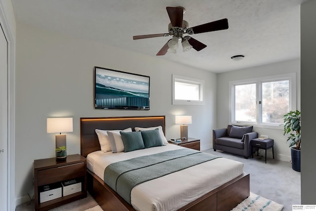 bedroom featuring multiple windows, ceiling fan, and light colored carpet