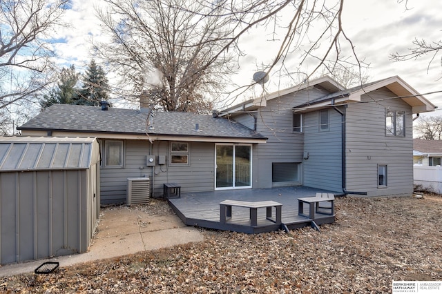 back of property with a storage unit, central AC unit, and a deck