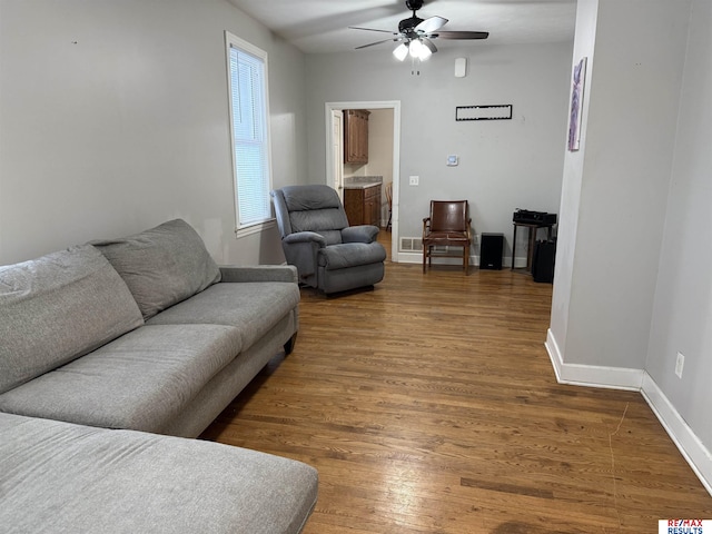 living area with ceiling fan, baseboards, and wood finished floors