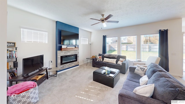 living room with a fireplace, a textured ceiling, light colored carpet, and ceiling fan