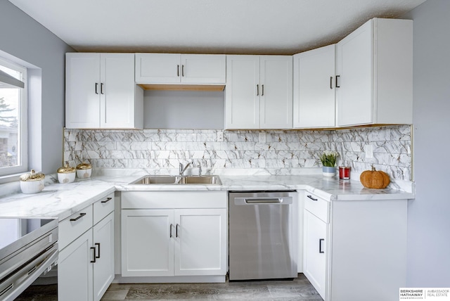 kitchen with white cabinets, stainless steel dishwasher, and light stone counters