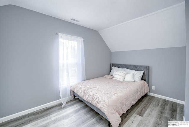 bedroom with lofted ceiling and hardwood / wood-style flooring